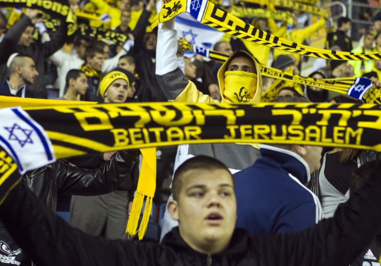 Fans of Beitar Jerusalem shout slogans during a match against Bnei Sakhnin as part of the Israeli Premier League (credit: REUTERS)