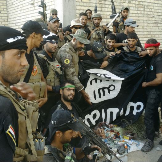 Iraqi security forces hold an Islamist State flag which they pulled down at the University of Anbar, in the western city of Ramadi on Sunday.