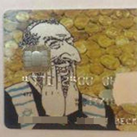 An anti-Semetic credit card features a hook-nosed Jew, laughing gleefully against a backdrop of gold coins