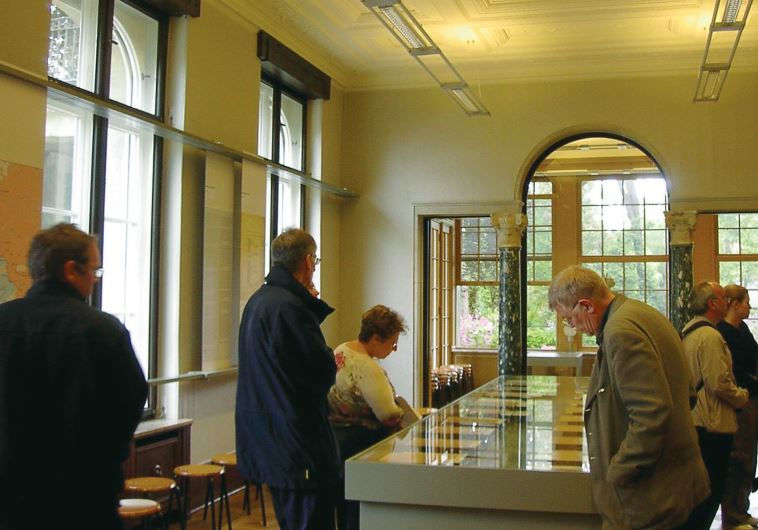 Visitors to the Wannsee House look at copies of the meeting’s minutes in the conference room.