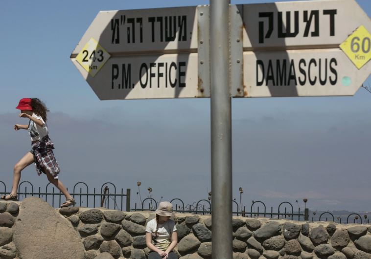 Girls play near a sign at Mount Bental, an observation post on the Israeli side of the Golan Heights, overlooking the Syrian side of the Kuneitra crossing