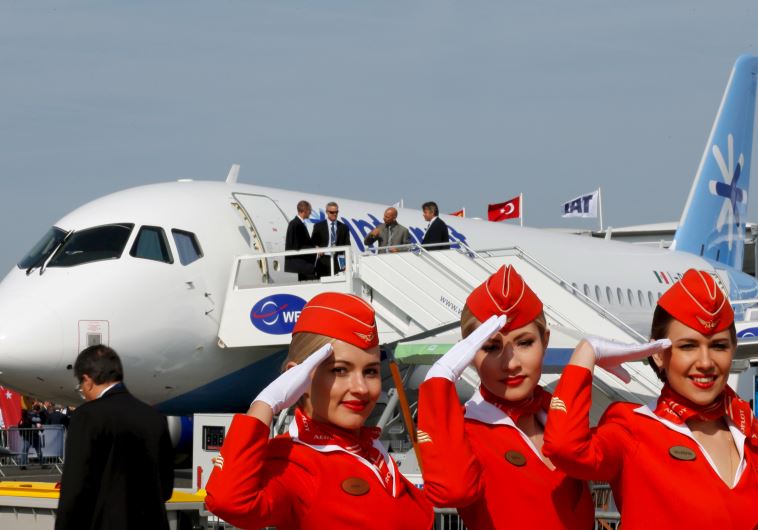 Cabin crew members of Russian carrier Aeroflot pose in front of a Sukhoi Superjet 100 airplane during a photo session at the 51st Paris Air Show at Le Bourget airport near Paris