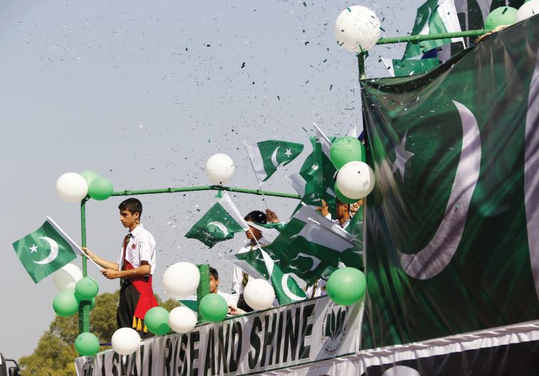 PEOPLE WAVE Pakistani flags at a rally earlier this year.