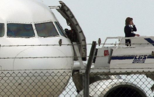 An official telephones from the ramp of a hijacked Egyptair A320 Airbus at Larnaca Airport in Larnaca, Cyprus, March 29, 2016