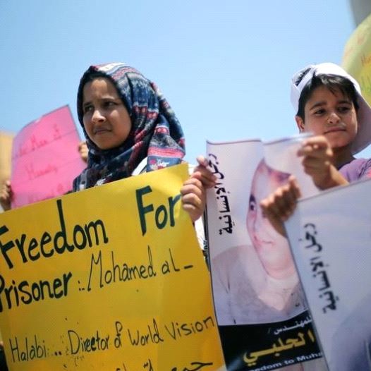Palestinian demonstrators take part in a protest in solidarity with Mohammad El Halabi, World Vision's manager of operations in Gaza who was accused by Israel of funnelling millions of dollars in aid money to Hamas, organised by foundations and societies benefiting from World Vision in Gaza City Aug