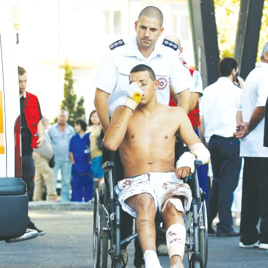 AN ISRAELI SURVIVOR of the Hezbollah bombing at Burgas, Bulgaria, on July 19, 2012, is wheeled to a waiting ambulance as he leaves the hospital.