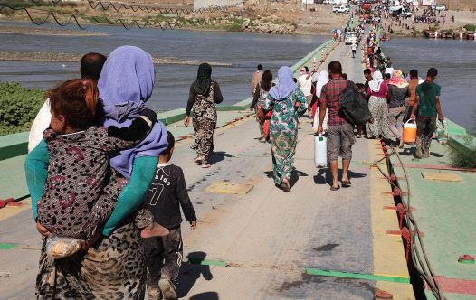 YAZIDI WOMEN and men flee Islamic State on August 10, 2014 in northern Iraq. Many were captured by ISIS, raped tortured and executed, a crime that continues to this day.
