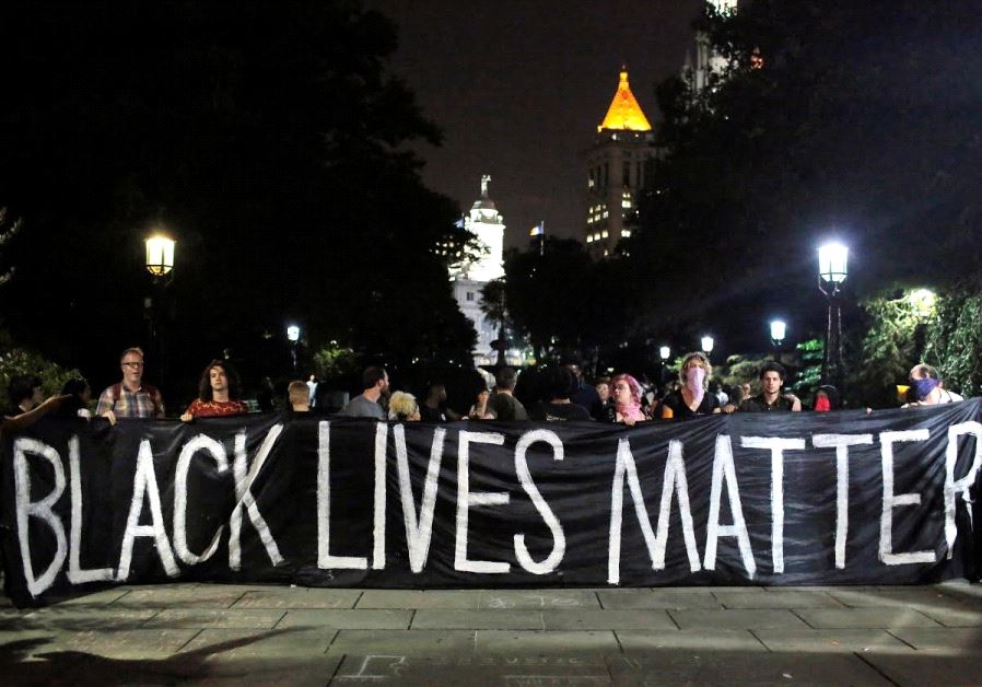 People hold up a banner during a Black Lives Matter protest outside City Hall in Manhattan, New York