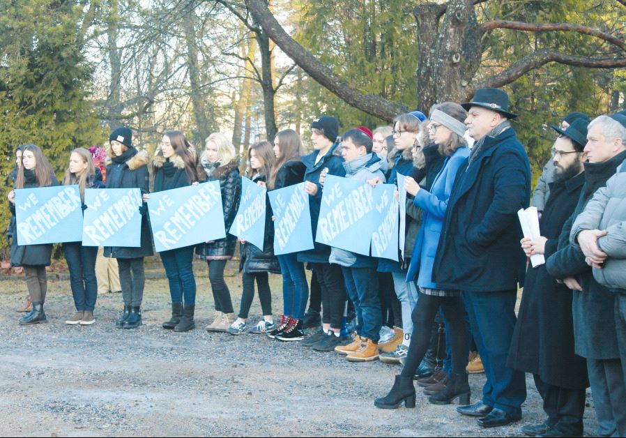 Jewish youth holding placards at the Tallinn cemetery. The rabbi of Estonia, Shmuel Kot, is second from the right