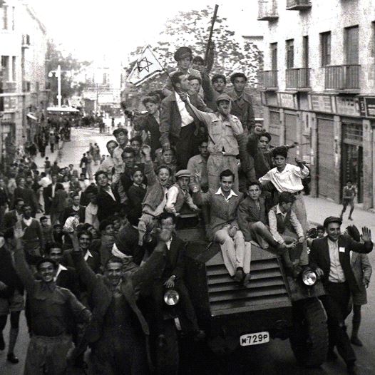 JEWS CROWD onto a British army armored car as they celebrate in downtown Jerusalem the morning after the United Nations voted to partition British mandate Palestine into a Jewish and an Arab state.