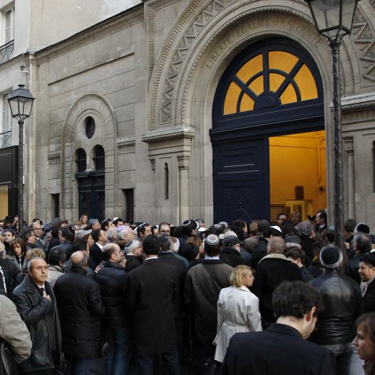 People gather outside the Notre-Dame de Nazareth synagogue in Paris March 19, 2012 to pay tribute to the four victims killed by a gunman at a Jewish school in Toulouse