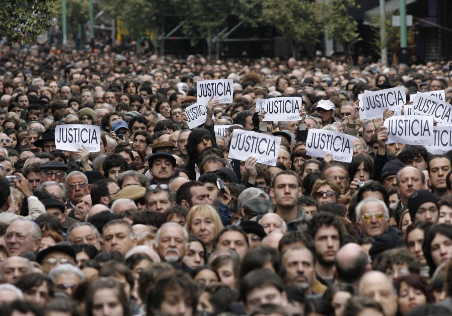 Hundreds of people, most of them members of the Argentine Jewish community, attend the commemoration of the 13th anniversary of the 1994 bombing of the AMIA Jewish community center in Buenos Aires July 18, 2007. The signs read, ''Justice.