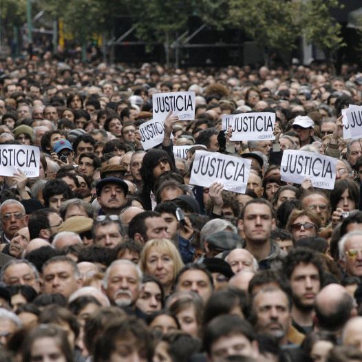 Hundreds of people, most of them members of the Argentine Jewish community, attend the commemoration of the 13th anniversary of the 1994 bombing of the AMIA Jewish community center in Buenos Aires July 18, 2007. The signs read, ''Justice.