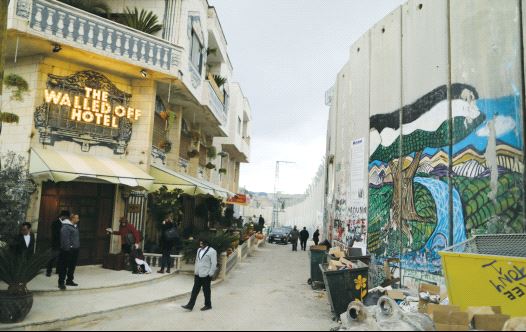 People stand outside the Walled Off Hotel, which was opened by street artist Banksy, in Bethlehem