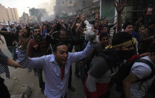 Supporters of the Muslim Brotherhood and ousted Egyptian President Mohamed Mursi shout slogans in front of riot police and army and their supporters, during clashes at El-Talbyia near Giza square, south of Cairo, November 29, 2013