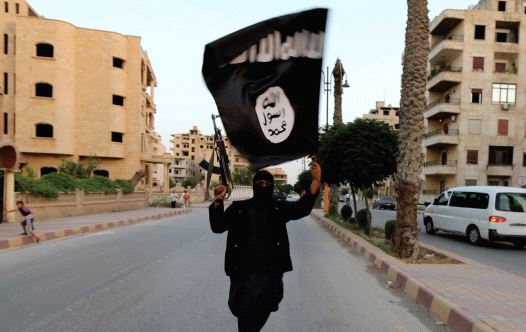 A MEMBER of ISIS waves the group’s flag in Raqqa