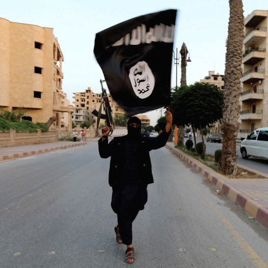 A MEMBER of ISIS waves the group’s flag in Raqqa