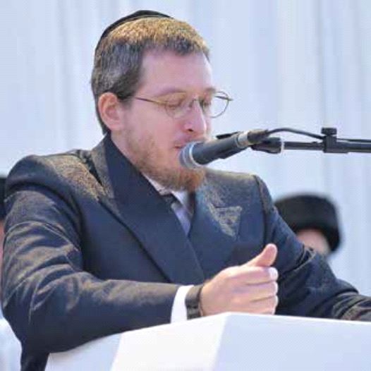 Menachem Bombach delivering remarks while introducing a new Torah scroll at a hassidic school last Shavuot.