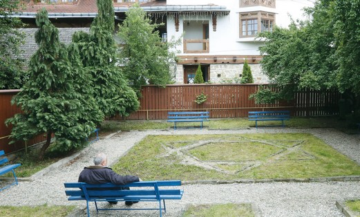 A MAN sits in the garden of the childhood home of Elie Wiesel