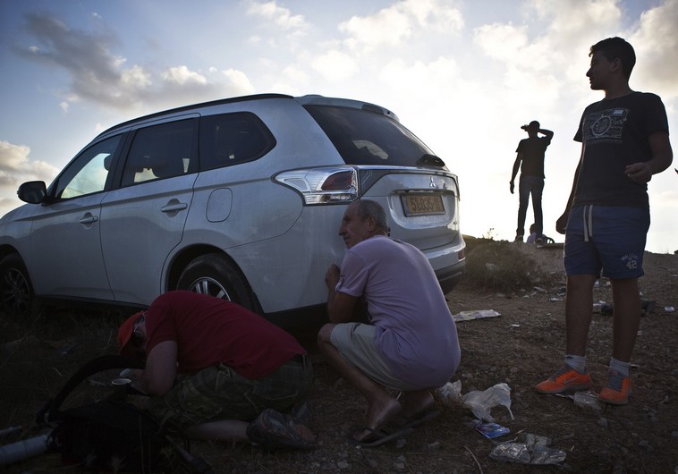 Some Israelis take cover as others look on as sirens indicating rockets being fired to the area are heard on a lookout hill near Sderot, opposite the northern Gaza Strip.