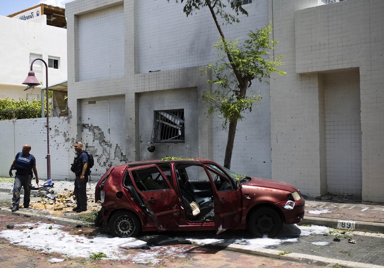 Israeli police survey the scene after a rocket fired from Gaza landed in Ashdod July 14, 2014.