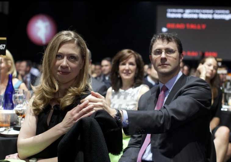 Chelsea Clinton and her husband Marc Mezvinsky (R) sit in the audience at the Robin Hood Foundation Benefit at the Jacob K Javits Convention Center in New York