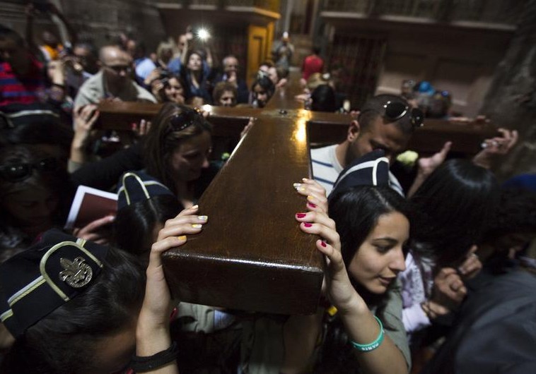 Christians carry a cross after a procession in the Church of the Holy Sepulchre on Good Friday, during Holy Week in Jerusalem's Old City