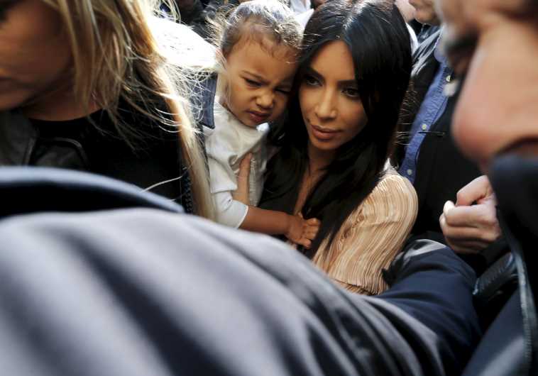 U.S. reality TV star Kim Kardashian (C) holds her toddler daughter North West as they arrive for a baptism ceremony at the Cathedral of Saint James in Jerusalem's Old City April 13, 2015.