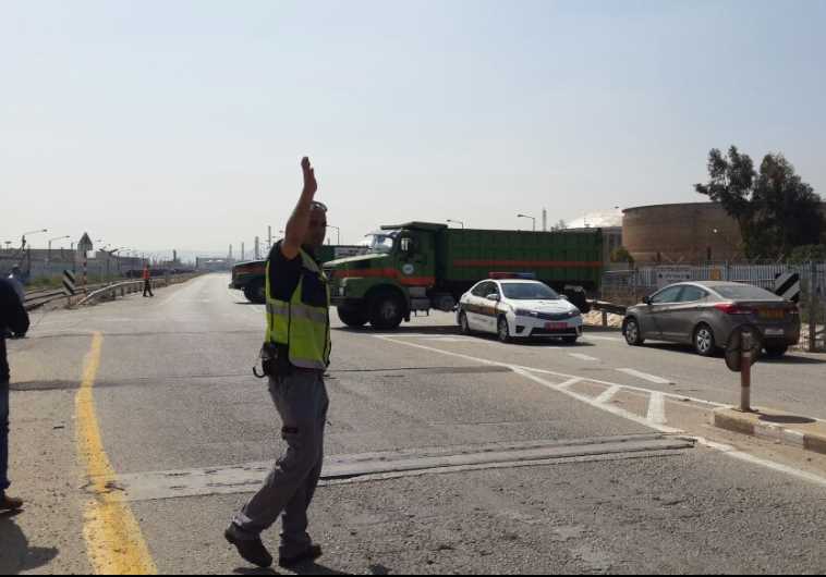 Municipal trucks block entrance to factories linked to air pollution. 