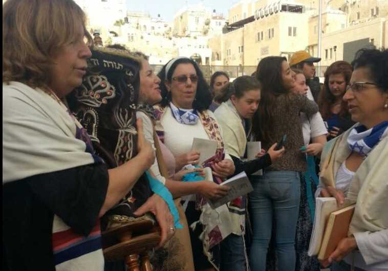 Women of the Wall carry a Torah scroll into the women's section of the Western Wall plaza