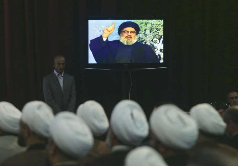 Hassan Nasrallah talks to his Lebanese and Yemeni supporters via a giant screen during a speech against US-Saudi aggression in Yemen, in Beirut’s southern suburbs on April 17.