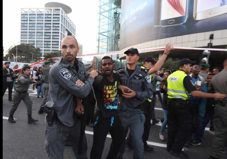 AN ETHIOPIAN-ISRAELI demonstrator is restrained by two policemen in downtown Tel Aviv on Sunday