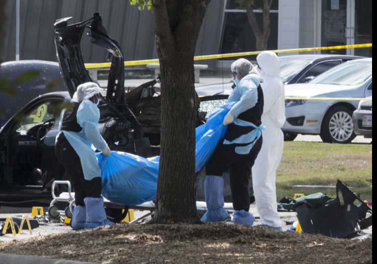 The bodies of two gunmen are removed from behind a car during an investigation by the FBI and local police in Garland, Texas May 4, 2015. 