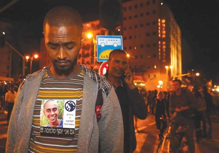 A man wears a sign that says ‘I am also Yosef Salamsa,’ an Ethiopian Israeli believed to have killed himself after alleged abuse by police.