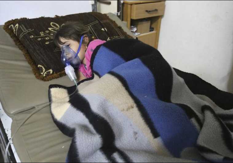 A girl, affected by what activists say was a gas attack, receives treatment inside a makeshift hospital in Kfar Zeita village in the central province of Hama