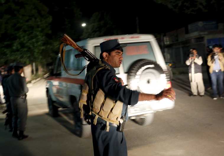 Afghan policeman stands guard at the site of an attack in Kabul