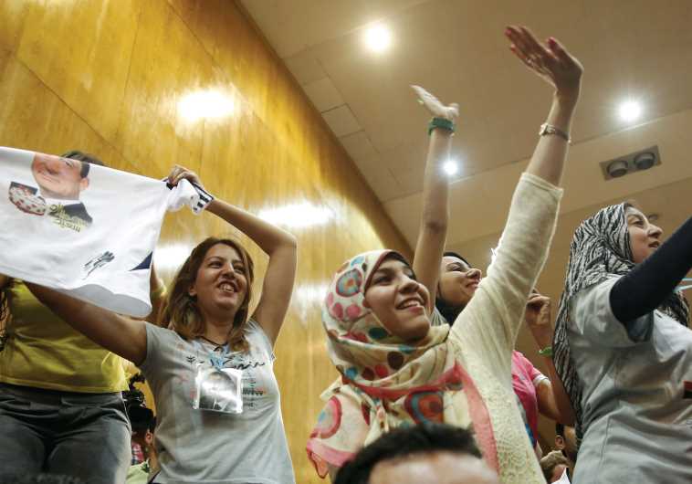 Supporters of Egypt’s former president Hosni Mubarak wave to him before the verdict is read on May 9, in the retrial of a corruption case.