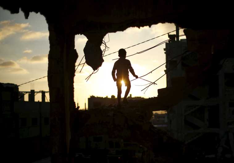 A Palestinian boy plays at a house that witnesses said was destroyed during Operation Protective Edge in the east of Gaza City