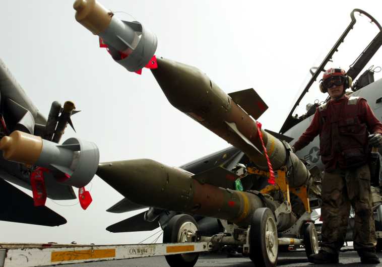 An aviation ordinanceman gets ready to load a couple of GBU-24 2000 pound "Bunker Buster" bombs onto aircraft on the flight deck of the USS Kitty Hawk aircraft carrier in the northern Gulf