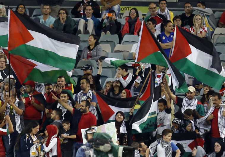 Fans of the Palestinian national team wave flags during their Asian Cup Group D soccer match against Iraq