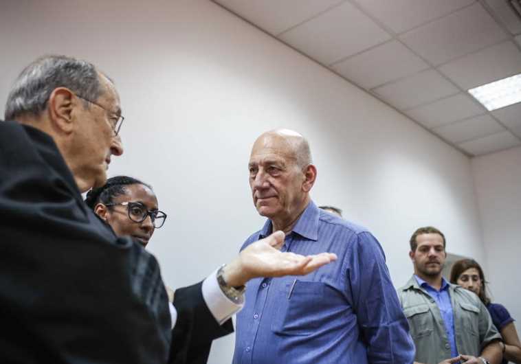 Ehud Olmert speaking with his lawyers, May 25, 2015