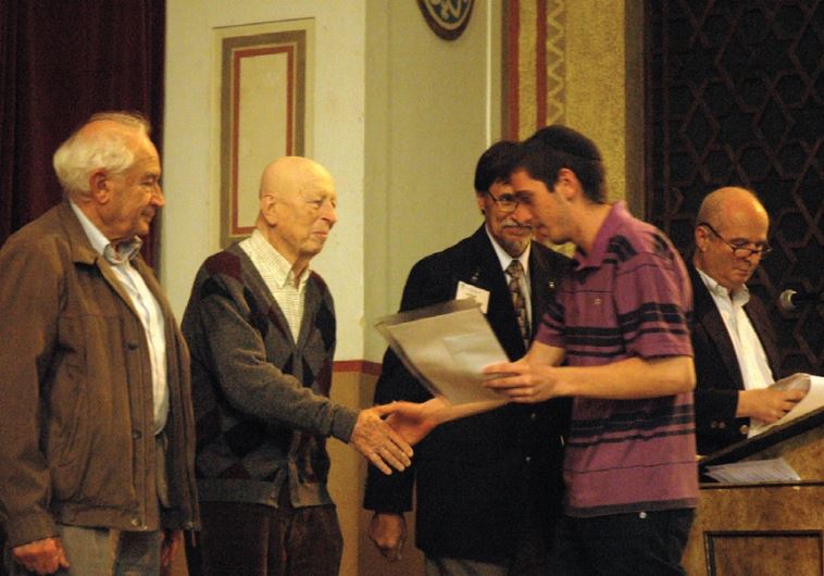 A high-school student receives an award from the Jerusalem Rotary Club.