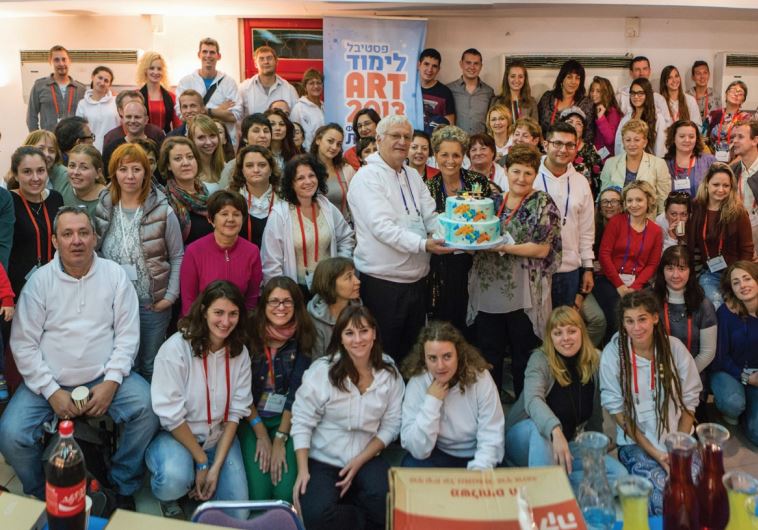 Limmud FSU founder Chaim Chessler, center with cake, together with secretarygeneral Diane Wohl and participants at Limmud FSU Art Jerusalem in 2012.