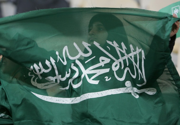 A Saudi Arabian woman waves the national flag during a soccer match at the West Asian Games in Doha