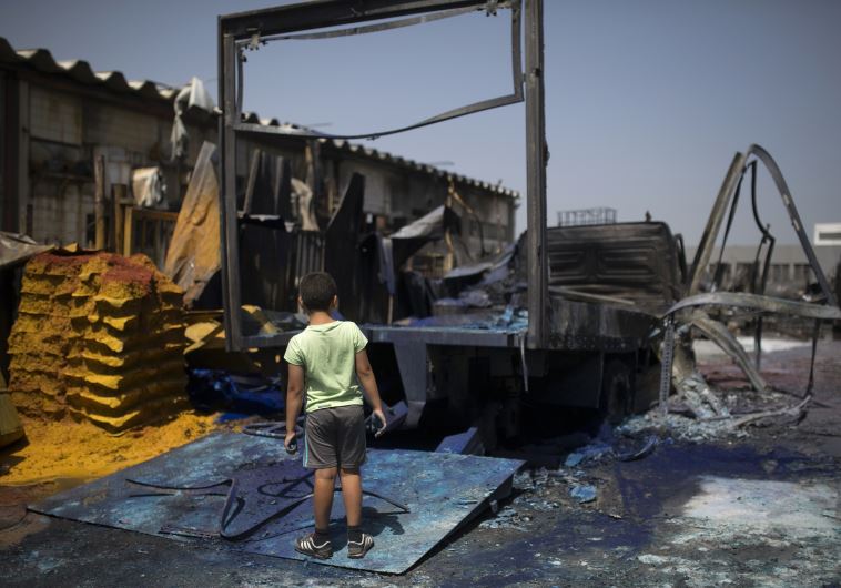 An Israeli boy looks at a burnt paint factory in the southern Israeli town of Sderot.