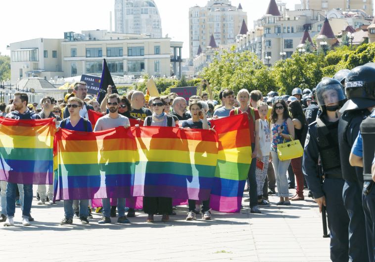 Ukrainian activists take part in an Equality March organized by the LGBT community, as Interior Ministry members stand guard.