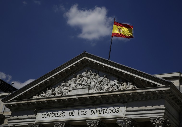 A Spanish flag waves over the Spanish parliament in Madrid