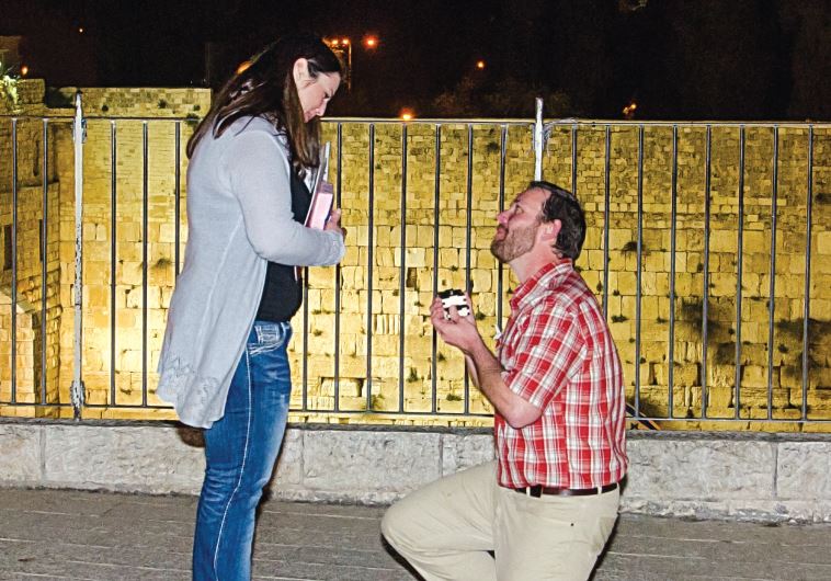 A man proposing marriage in front of the Western Wall at the end of an Israel ScaVentures scavenger hunt.