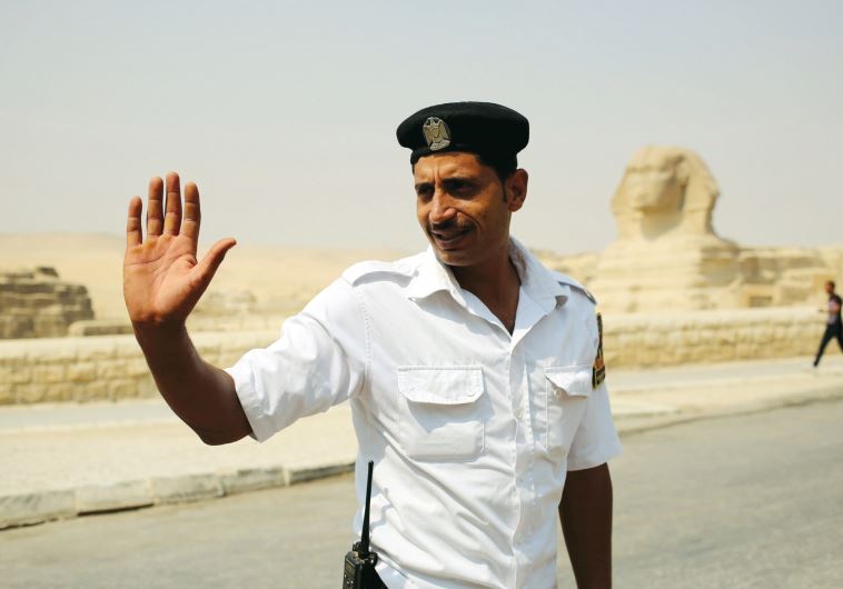A policeman gestures to people as he stands guard near the Sphinx, in Giza on June 11.