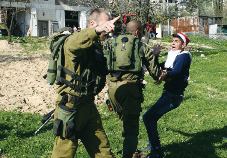 A soldier detains a Palestinian protester during a demonstration at the Hawara checkpoint in January.